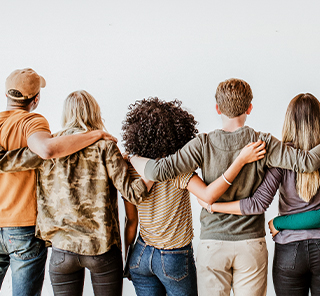 A group hugging, backs turned.